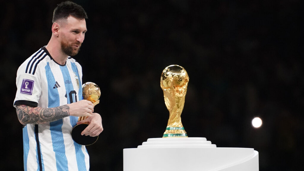 Lusail, Qatar, 18 december 2022. Lionel Messi med Guldbollen tittar på VM-trofén. Argentina mot Frankrike, Match 64, Finalmatchen av