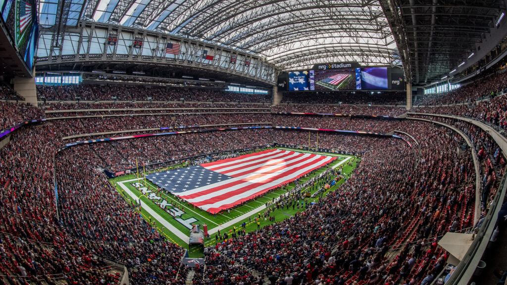 En allmän vy över NRG Stadium där en gigantisk amerikansk flagga täcker planen under nationalsången, före en Wild Card-slutspelsmatch mellan Houston Texans och Indianapolis Colts i Houston den 5 januari 2019.