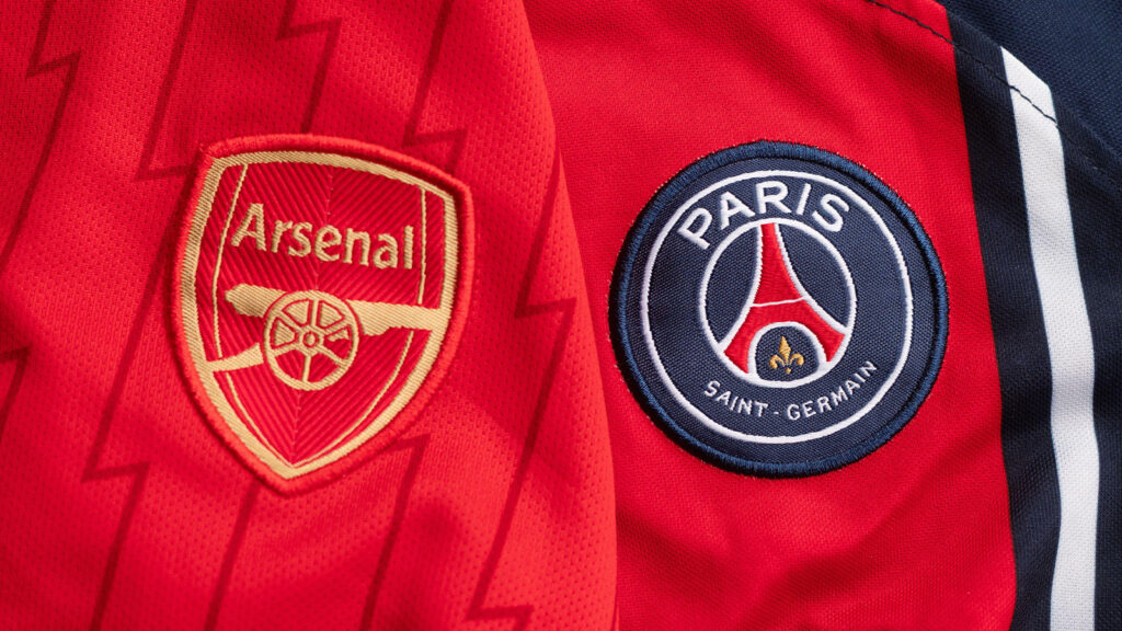 Ukraine, Kyiv – 8 maj 2026. Närbild på fotbollströjor från Arsenal FC och Paris Saint-Germain FC som visar klubbmärken och lagens starka färger.